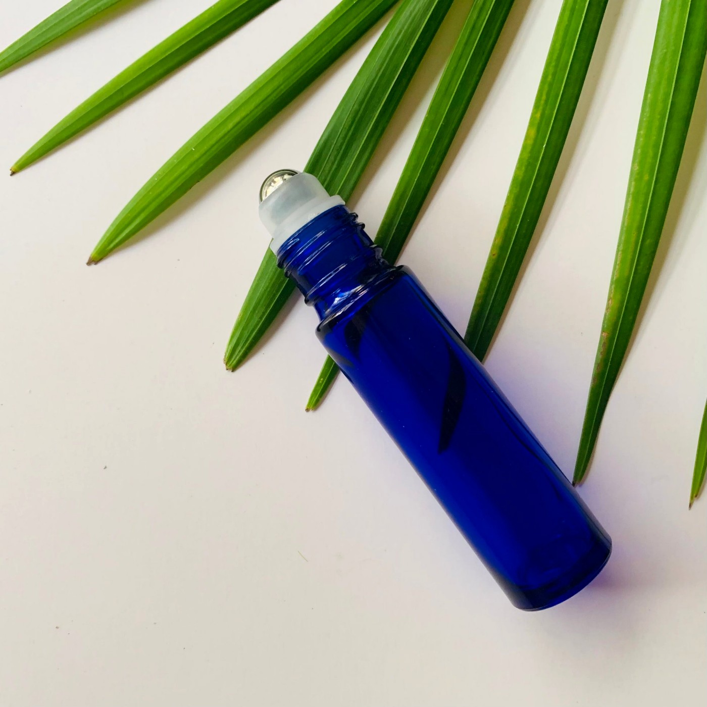 Ash & Eden Essentials deep tissue roll-on bottle with palm leaf